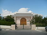 Ein kleines Mausoleum, von Büschen umgeben