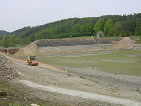 Staudamm und entleerter Stausee am Beginn des Rückbaus im Mai 2007