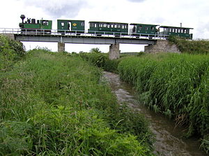 Dampflokomotive „András“ mit Personenzug auf der Brücke über die Ikva
