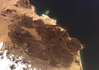 Das Vulkanfeld Bal Haf füllt den größten Teil dieser Aufnahme eines NASA-Astronauten an Bord eines Space Shuttles aus. Dunkel gefärbte Lavafelder machen den Hauptteil dieses Vulkanfeldes aus und schaffen eine irreguläre Küstenlinie. Zwei große Tuffkegel sind sichtbar entlang der Küste im Bild links oben, der obere enthält einen Kratersee.