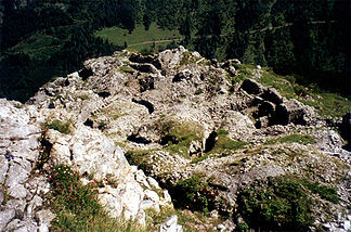 Blick vom Gipfel auf die ehemaligen in den Fels gebauten Stellungen und Schützengräben