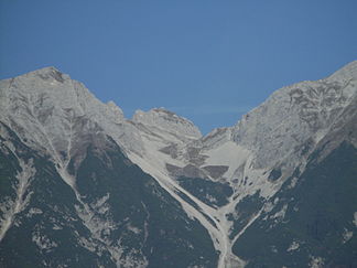 Gleirschtaler Brandjoch über der Arzler Scharte von Süden. Links die Mandlspitze (2.366 m), rechts der Westgrat der Rumer Spitze (2.454 m)
