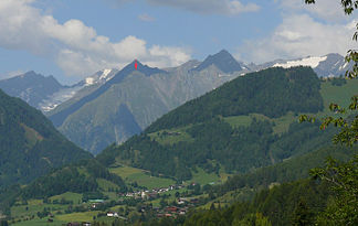 Mullwitzkogel (roter Pfeil), gesehen von Zedlach (von Osten).  Er wird umrahmt von den Dreitausendern (von links): Daberspitze, Rötspitze, Ogasil (direkt hinter Mullwitzkogel), Steingrubenkogel, Quirl und den Malhamspitzen.