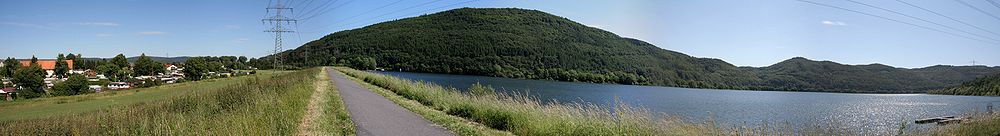 Affolderner See mit seinem Staudamm, einigen Häusern von Affoldern und dem 439,3 m hohen Berg Rabenstein