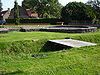 Gelände mit Fundamenten aus einem Eintrittstor mit anschließender Festungsmauer und Spuren eines Wassergrabens, eines Zugangswegs und einer Brücke aus der Zeit des Römischen Reichs