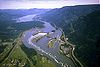 Luftphotographie des Bonneville Dams an einem sonnigen Tag; sichtbar sind der Staudamm, die Einrichtungen und die Landstraßen beiderseits des Flusses und die umgebende Columbia River Gorge.