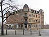 Wohn- und Geschäftshaus Sidonienstraße 1, links im Hintergrund der Uhrenturm des Bahnhofsgebäudes Radebeul Ost. Hinter dem Haus liegt der Radebeuler Krater.