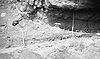Photographie der archäologischen Ausgrabungen von Fort Rock Cave, Werkzeuge und Messinstrumente in einem felsigen Ausgrabungsgebiet.