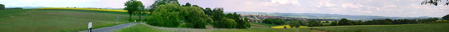 Blick von Richtung Westen auf Wasenberg, die Wasenberger Terrassen und den Knüll mit dem Knüllköpfchen (634 m, Windkraftanlage) und dem Kirschenwald (bis 533 m, rechts); Links der Baumgruppe der Berg Altenburg (433 m) bei Bad Zwesten, den nach links das Tal der Schwalm vom Kellerwald (ganz links der 675 m hohe Wüstegarten) trennt