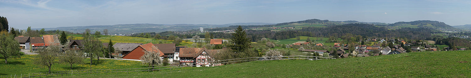 Der Blick über die Thurgauer Landschaft. Im Vordergrund das Dorf Häuslenen. In der Bildmitte das Thurgauer Kantonsspital, ein markanter Referenzpunkt in dieser Landschaft. Links davon im Hintergrund der lang gezogene Seerücken, der das Thurtal gegen den Bodensee abgrenzt. Nach rechts geht es ansteigend bis zum Stählibuck mit seiner bewaldeten Kuppe. Die Fortsetzung der Hügelkette endet ganz rechts im Bild mit dem Imenberg auf dessen Vorderkante das Schloss Sonnenberg thront.