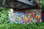 NME-Eisenbahnbrücke mit Namensschild und Graffiti
