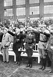 Foto: King inmitten von Personen, die den Arm zum Hitlergruß ausstrecken