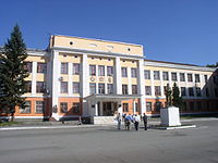Hauptgebäude der Tschkalow-Flugzeugwerke NAPO in Nowosibirsk mit einer Gedenkstatue von Tschkalow