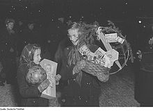 Schwarzweiß-Fotografie von zwei Kindern mit Geschenken auf dem Arm