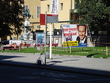 Wahlplakat der Freiheitlichen Partei Österreichs mit dem Konterfei Heinz-Christian Straches. Der Slogan lautet: „Soziale Sicherheit für unsere Leut’. Sie sind gegen ihn, weil er für euch ist.“