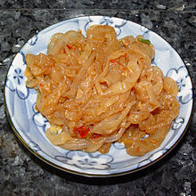 Photo of gold-colored jellyfish strips on plate.