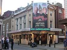 Exterior view of theatre with large poster advertising the current attraction.