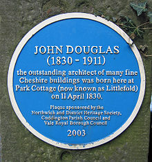 Eine runde blaute Tafel mit den englischen Aufschrift "JOHN DOUGLAS (1830–1911) the outstanding architect of many fine Cheshire buildings was born here at Park Cottage (now known as Littlefold) on 11 April 1830. Plaque sponsored by the Northwich and District Heritage Society, Cuddington Parish council and Vale Royal Borough Council 2003"
