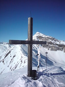 Gipfelkreuz. Im Hintergrund der Piz Grisch