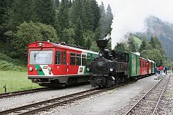 Triebwagen und Dampfzug im Bahnhof Ramingstein-Thomatal