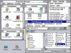 Bildschirmfoto Windows for Workgroups 3.11 (deutsch) mit Datei-Manager, im Hintergrund Programm-Manager mit geöffneten und geschlossenen Programmgruppen, der im Editor geöffneten Datei WIN.INI (mit Einträgen, die damals noch nicht Teil der Systemregistrierung waren) und unten links auf Symbolgröße minimierte Windowsanwendungen