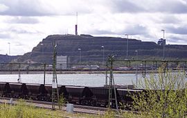 Der Erzberg Kiirunavaara mit Lüftungsschacht der Grube und Verwaltungsgebäude im Vordergrund.