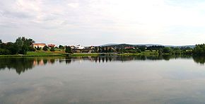 Der Erlauzwieseler See. Am gegenüberliegenden Ufer sind die Seebühne und der Ort Erlauzwiesel zu erkennen.
