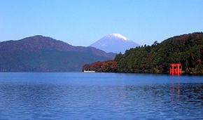 Aufnahme des Ashi-Sees von dessen Südostseite. Im Hintergrund ist der Fujisan zu erkennen, rechts das rote Torii des Hakone-Schreins.
