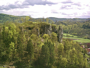 Blick vom Felsen Schauertaler Turm im Westnordwesten zu Felsen des Streitbergs der Ruine Streitburg; im Hintergrund − jenseits des Wiesenttals − Burgruine Neideck