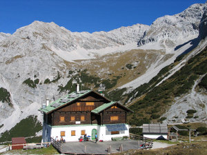 Die Pfeishütte vor dem Sonntagkar, im Hintergrund Gipfel der Gleirsch-Halltal-Kette Sonntagkarspitze (2.575 m), Bachofenspitze (2.668 m) und die Ausläufer des Roßkopfes (2.670 m), von links