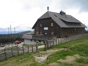 Roseggerhaus mit Windpark und Steinriegel im Hintergrund