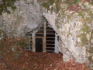 Eingang der Mondmilchhöhle mit Gitter und Durchstieg