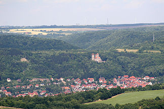 Blick vom Heldrastein über Treffurt, etwa mittig am Horizont das Rode mit Sendemast und zwei Windkraftanlagen.