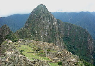 Der Huayna Picchu ragt im Hintergrund der Inkaruinen von Machu Picchu auf