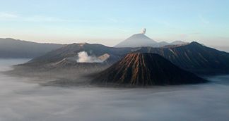 Bromo (rauchender Krater links) mit Batok (rechts vorne). Im Hintergrund Gunung Semeru.
