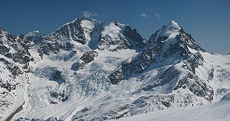 In der Bildmitte der Piz Scerscen, rechts der Piz Roseg, knapp links der Bildmitte der Piz Bernina mit dem Biancograt