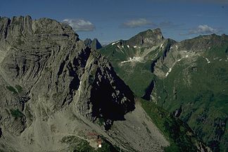 Wiedemer Kopf (Berg am linken Bildrand) von Nordosten. Weitere Gipfel (von links nach rechts): die viergipflige Höfats im Hintergrund, Schneck mit seiner Ostwand, die drei Gipfel des Rotkopf am rechten Bildrand.