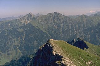 Rauhhorn (der mittlere Berg im mittleren Kamm) vom oberen Teil der Pfannenhölzer, kurz unterhalb des Kleinen Daumens. Links daneben das Gaishorn, rechts daneben die begraste Kuppe des Kugelhorns