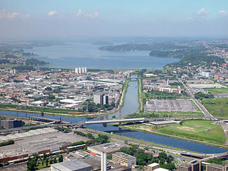 Luftbild des Zusammenflusses von Rio Guarapiranga und Rio Grande zum Rio Pinheiros mit dem Guarapiranga-Stausee im Hintergrund.