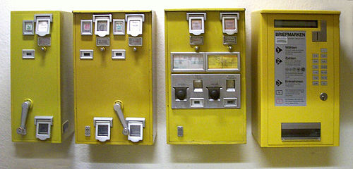Historische Briefmarkenautomaten: (von links nach rechts) Zwei mit Drehkurbel für Rollenmarken, Automat zum Ziehen von Briefmarkenheftchen und ein moderner für Automatenbriefmarken