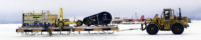 Ein riesiger Frachtschlitten, der von einem Radlader gezogen wird – an der McMurdo Station in der Antarktis