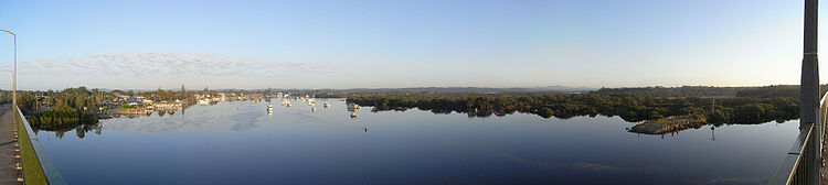 Panoramablick von der Singing Bridge Richtung Nordwesten den Myall River entlang. Links ist der Hafen von Tea Gardens, rechts das Koala-Reservat von Hawks Nest. Die Bootsrampen an beiden Seiten zeigen die alte Fährverbindung.