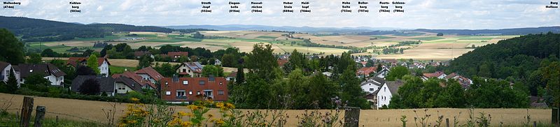 Blick von der Weinstraße nach Norden auf Goßfelden, die Wetschaft-Senke und das Rothaargebirge;gut erkennbar von links nach rechts der Wollenberg (474 m), der Kohlenberg (583 m), die Ziegenhelle (816 m), der Heidekopf (704 m), der Bollerberg (757 m), der Reetsberg (792 m), der Schloßberg (790 m) und der Burgwald mit Burg Mellnau